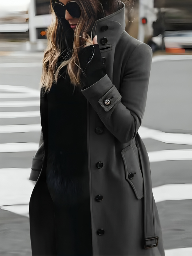 Stylish long women's coat with a high collar and elegant bow belt